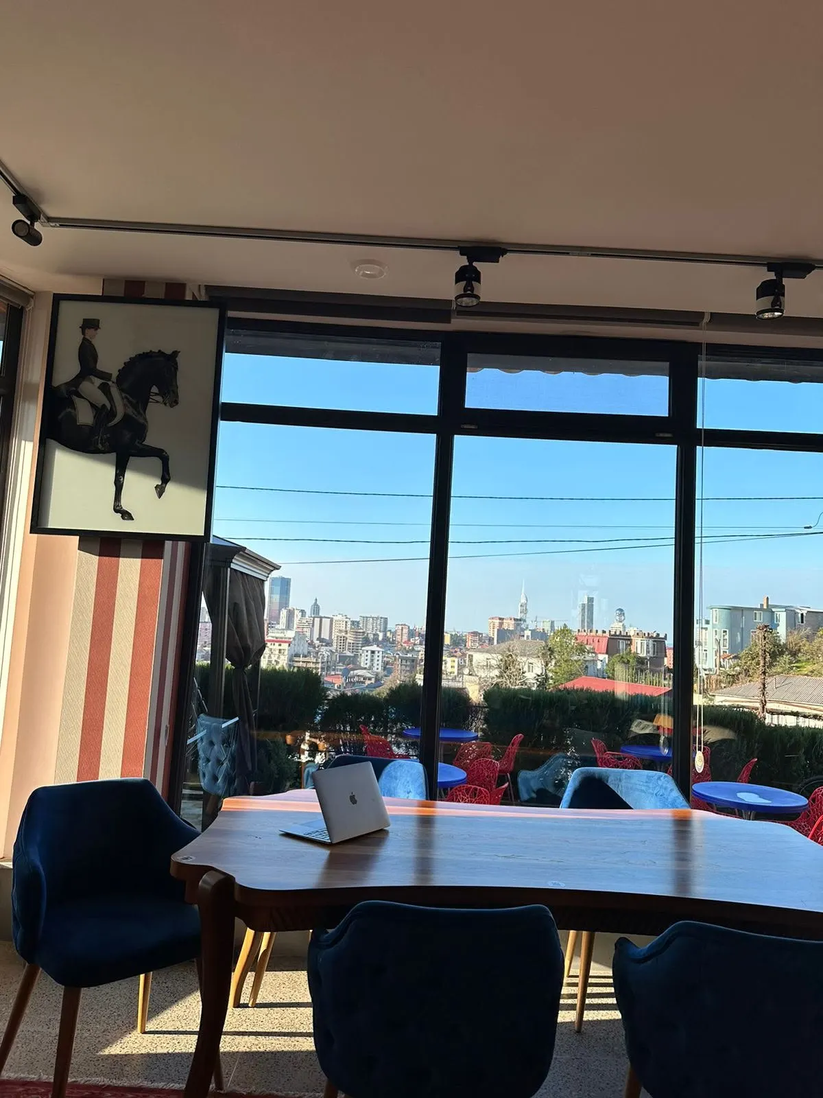 A wooden dining table in front of panoramic windows