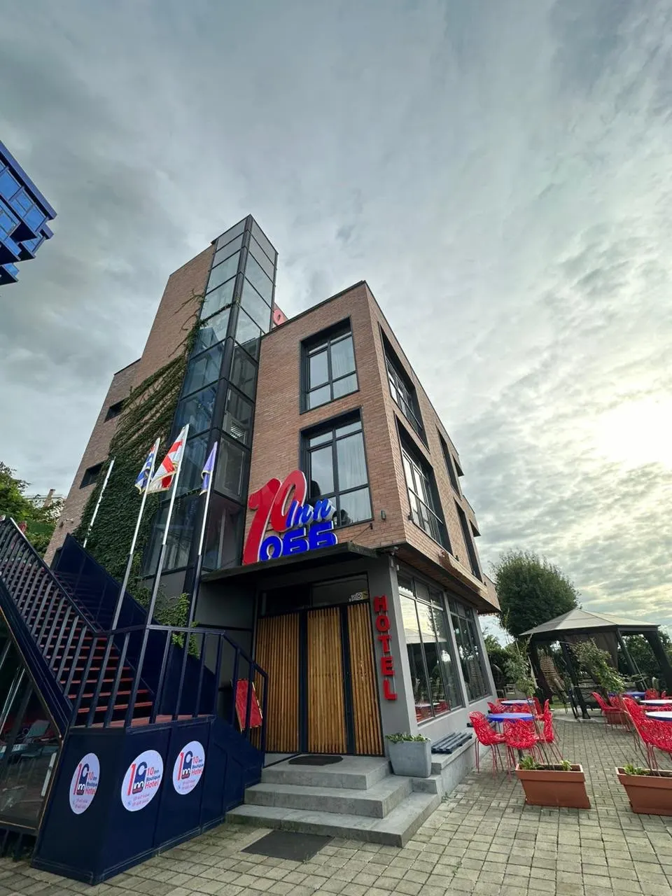 The hotel entrance with flags and the illuminated 10 Inn sign
