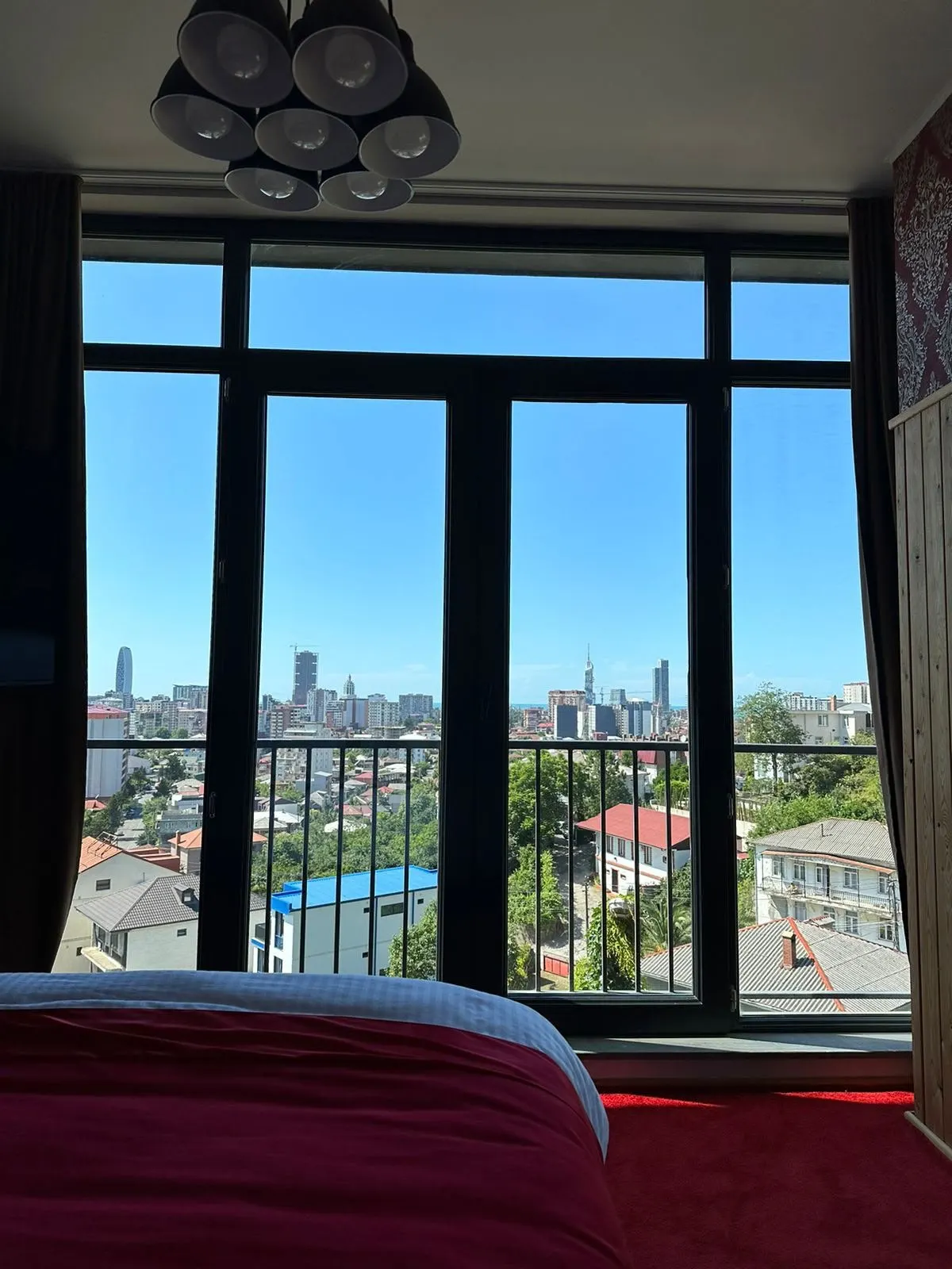 Bedroom with full-height windows and a French balcony over Batumi