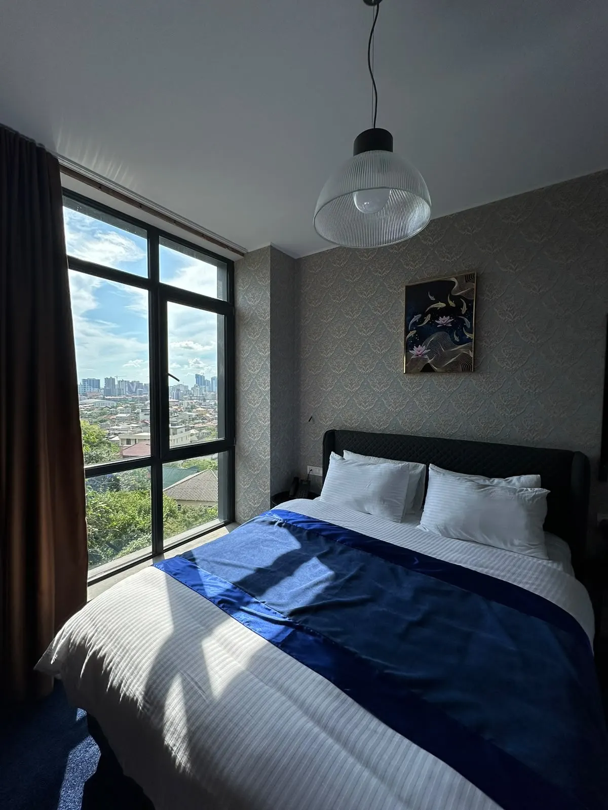 Bright double room with navy throw and a city view