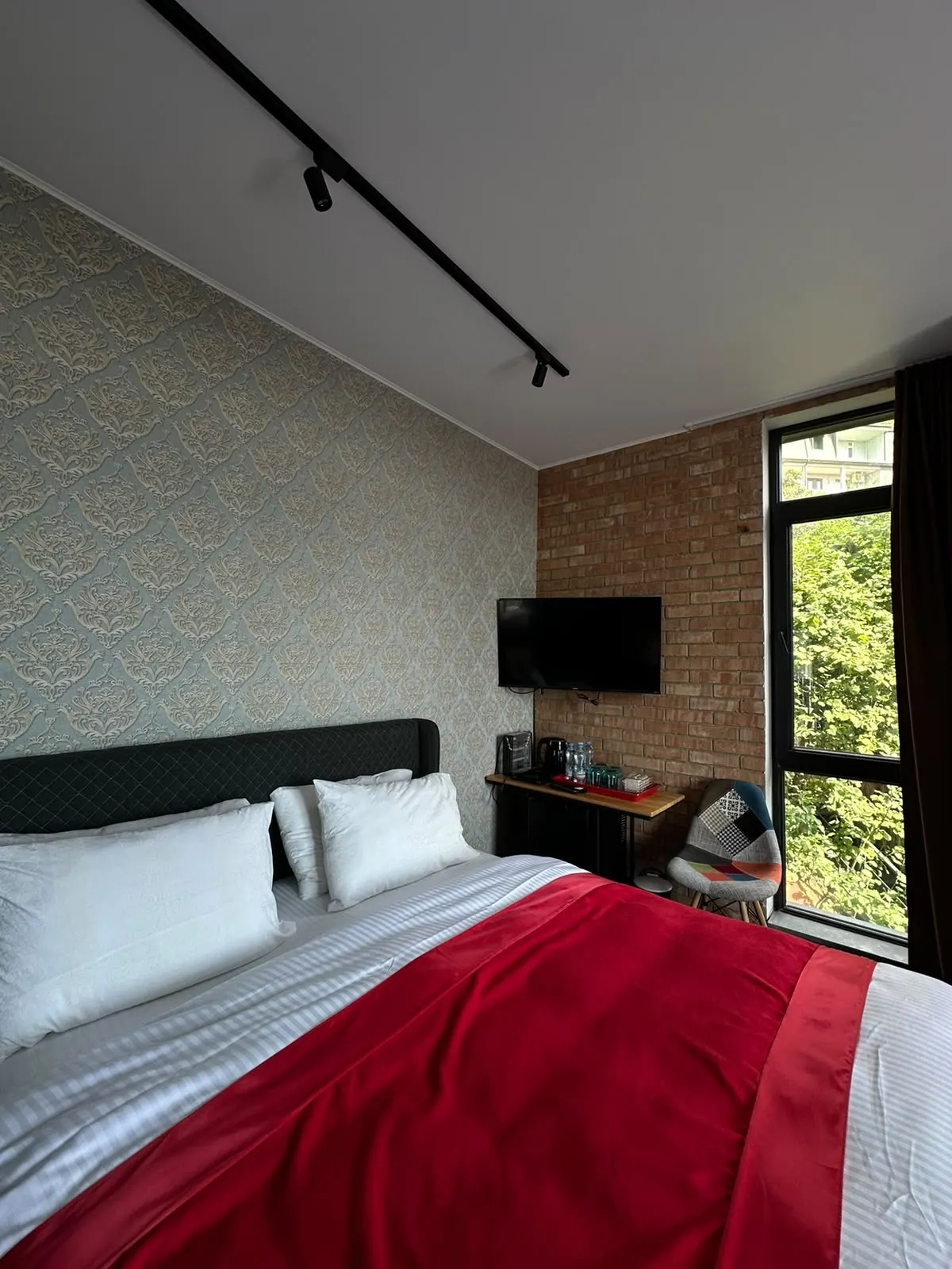 Double room with exposed brick wall and red throw