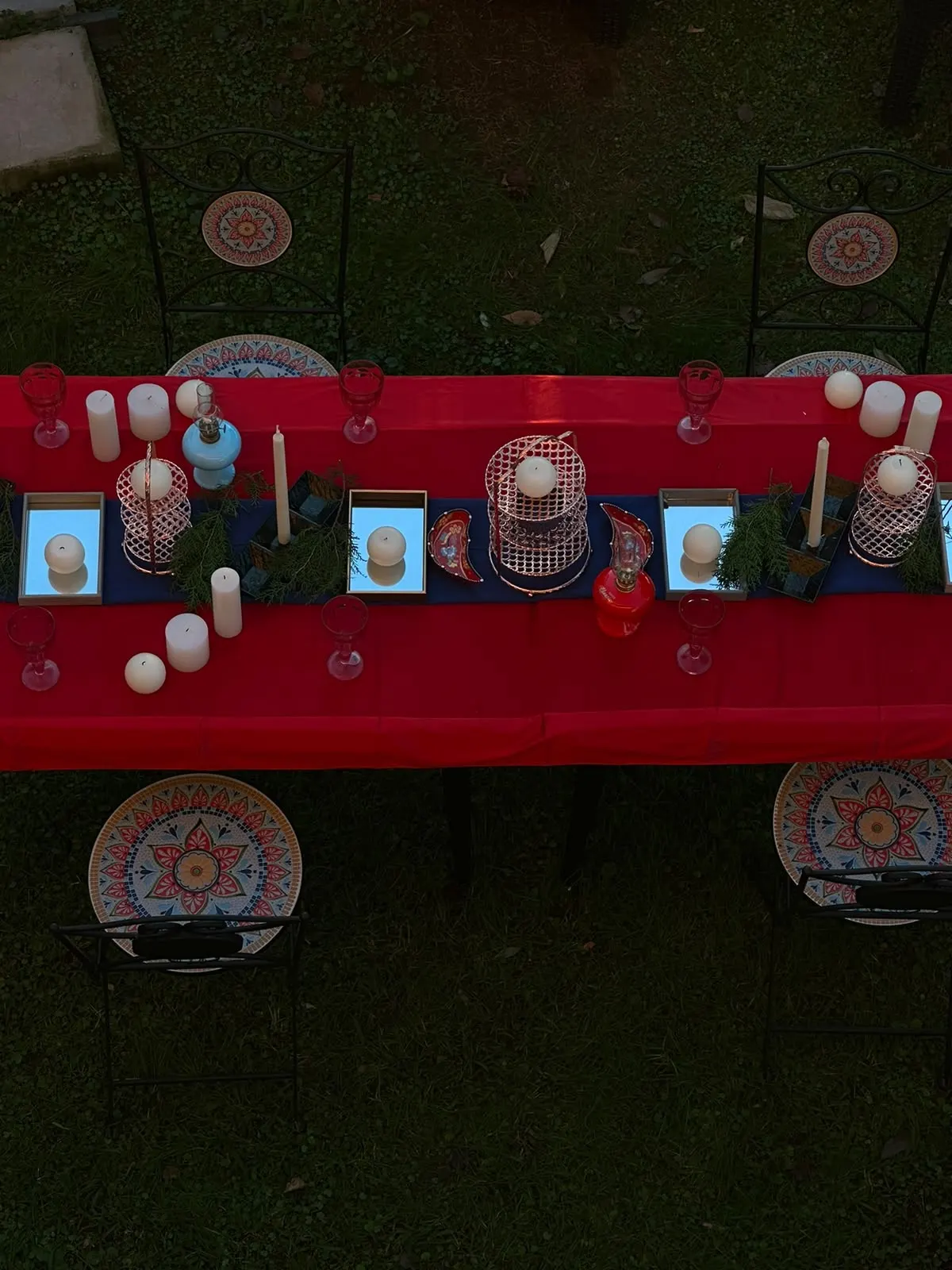 A celebration table with candles and mosaic plates, seen from above