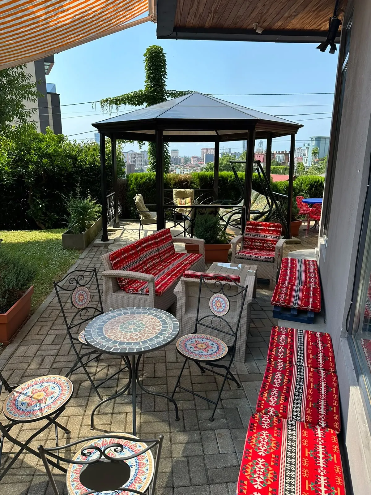 Covered terrace with sofas, mosaic tables and a gazebo