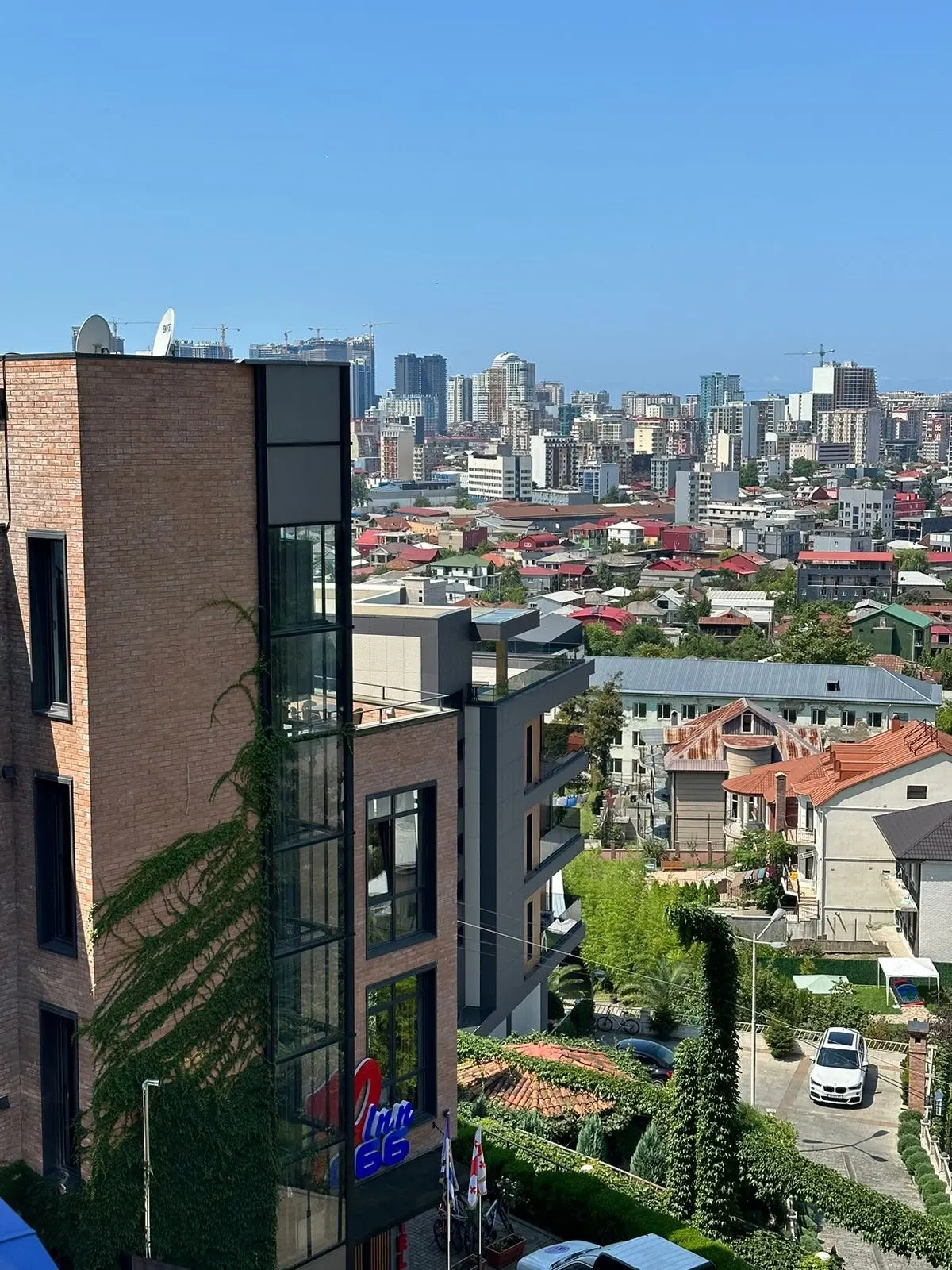 Ivy-covered hotel wall with Batumi’s skyline beyond